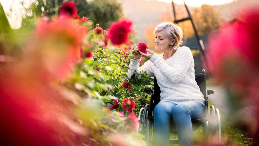 woman in garden smelling flowers
