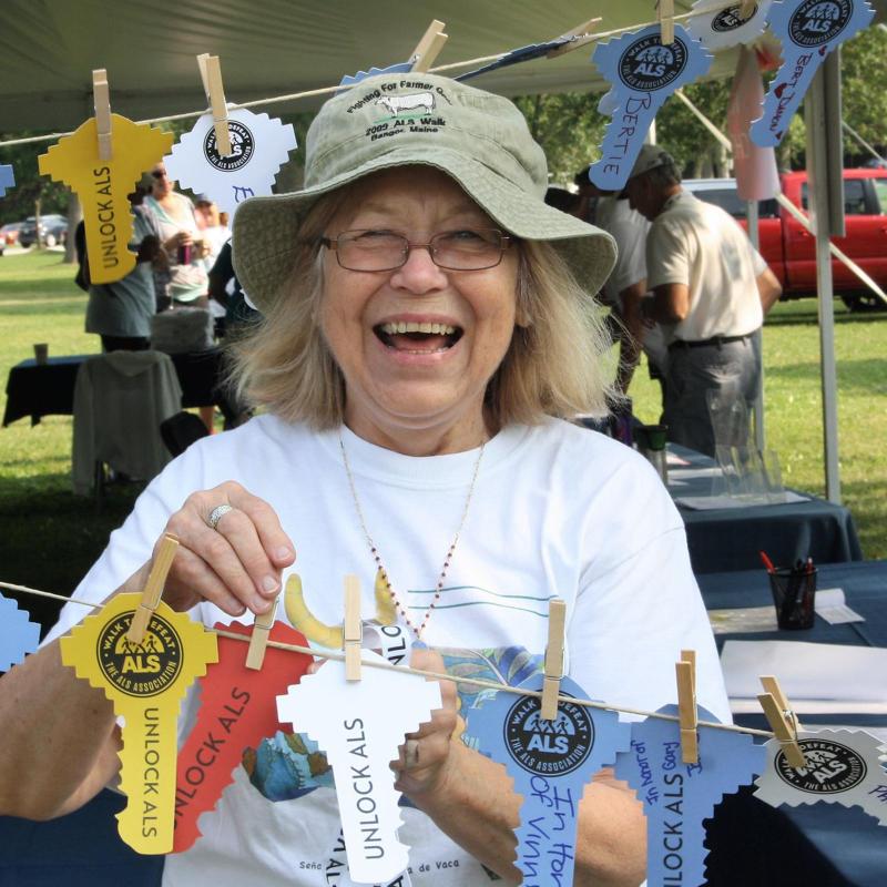 Woman smiling while volunteering at a Walk to Defeat ALS event